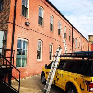 Critter Control truck with ladders ready for commercial building inspection in Springfield, MO
