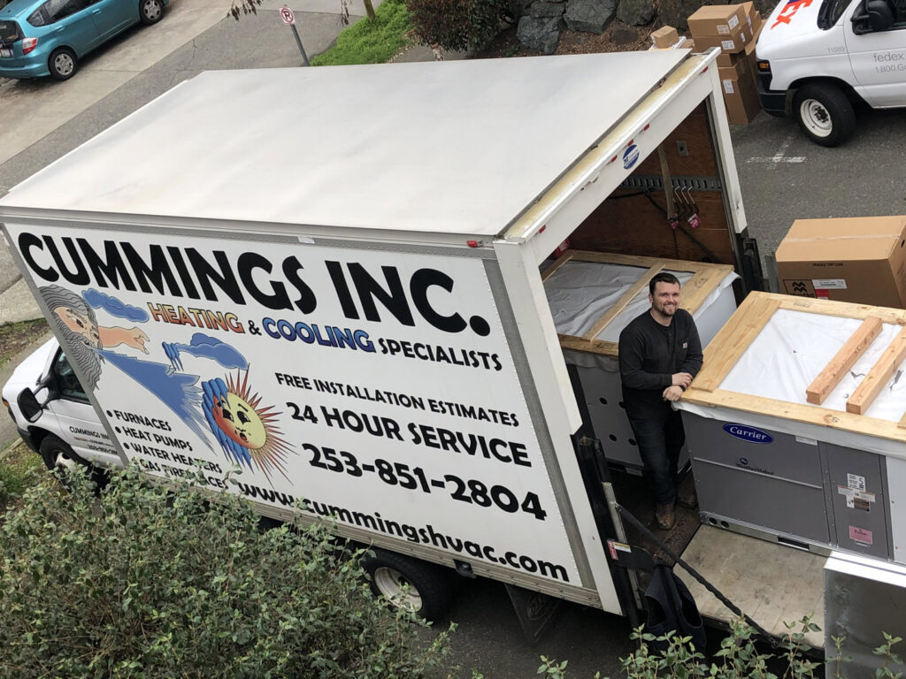 A Cummings Inc. truck delivering new HVAC units, including Carrier brand equipment, in Puyallup, WA.