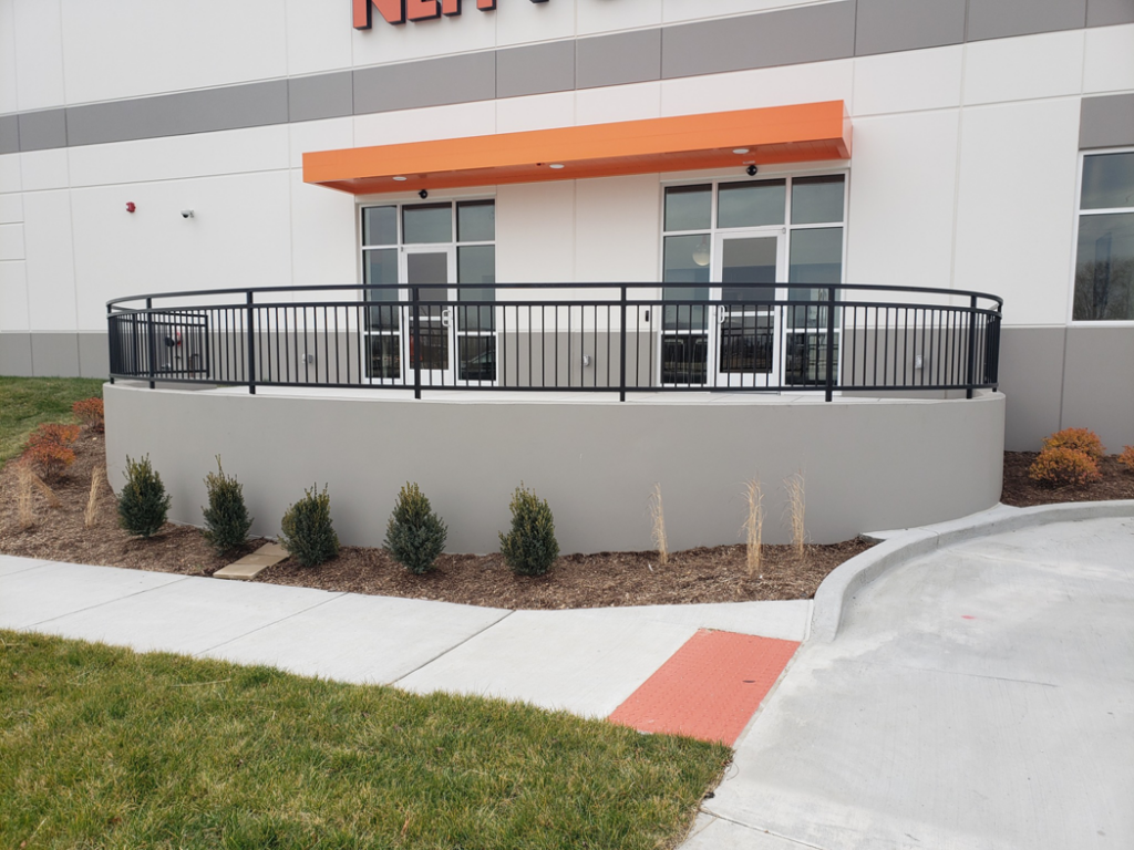 A curved black metal railing installed around a commercial building's entrance or patio by Missouri Ornamental Iron and Fence in St Louis, MO.