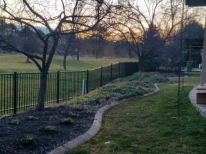 A curved black metal fence installed along a landscaped backyard by Double A Fence LLC in Boise, ID.