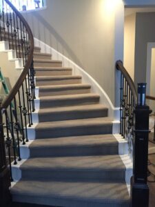A beautifully installed beige carpet on a curved staircase by Infinite Floors Kitchens Bathrooms in Burnsville, MN