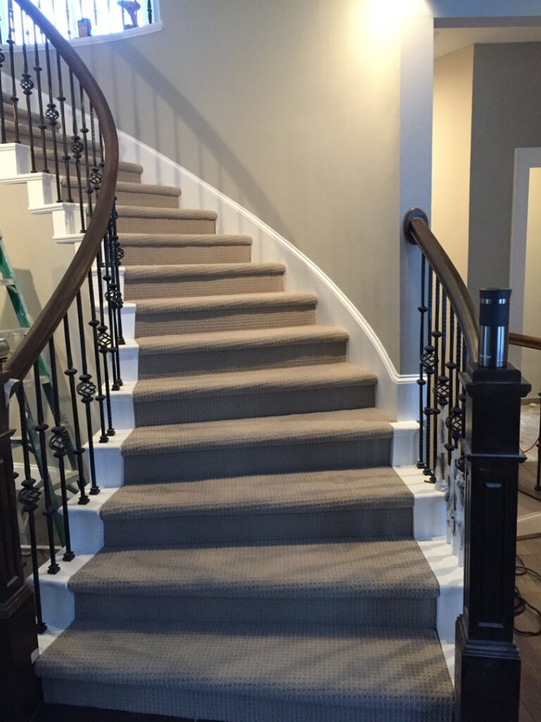 A beautifully installed beige carpet on a curved staircase by Infinite Floors Kitchens Bathrooms in Burnsville, MN