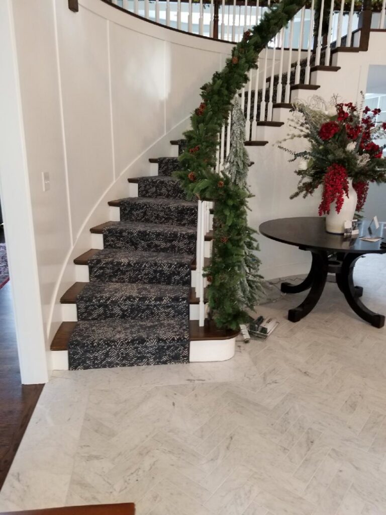 A beautifully installed patterned carpet runner on a curved staircase by Vogel's Carpet & Flooring in Seattle, WA
