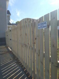 A beautiful new curved-top wooden privacy fence installed by Sunrise Fences in Goose Creek, SC, enhancing home security.
