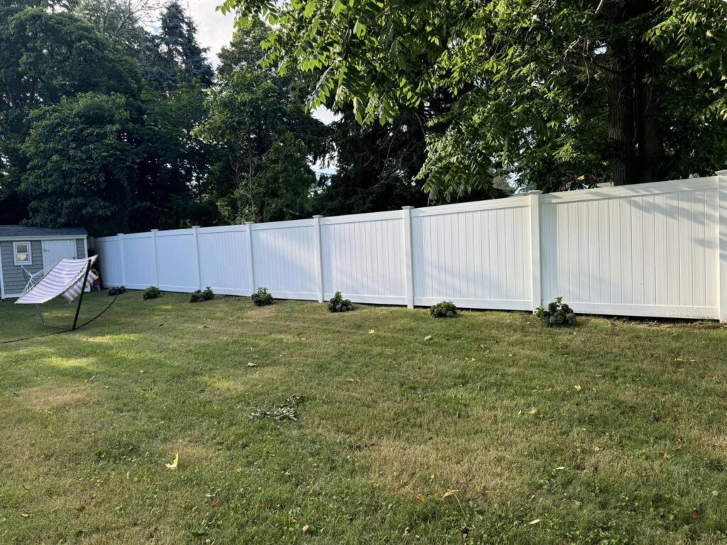 Curved white vinyl privacy fence installed in a residential backyard by Select Fence & Guardrail in North Haven, CT.