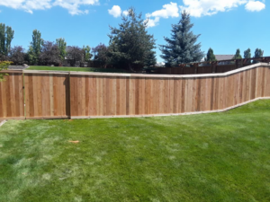 A curved wooden privacy fence installed in a spacious backyard by The Best Fence Company in Spokane, WA.