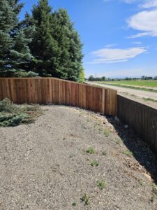 A beautifully installed curved wood privacy fence along a property line, completed by Regan Fencing & Services in Nampa, ID.