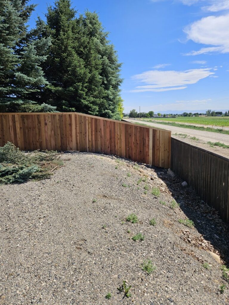 A beautifully installed curved wood privacy fence along a property line, completed by Regan Fencing & Services in Nampa, ID.
