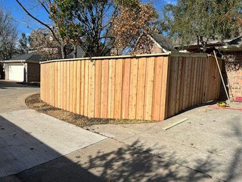 A newly installed curved wood privacy fence by Straight Shot Solutions, LLC in Fort Worth, TX.