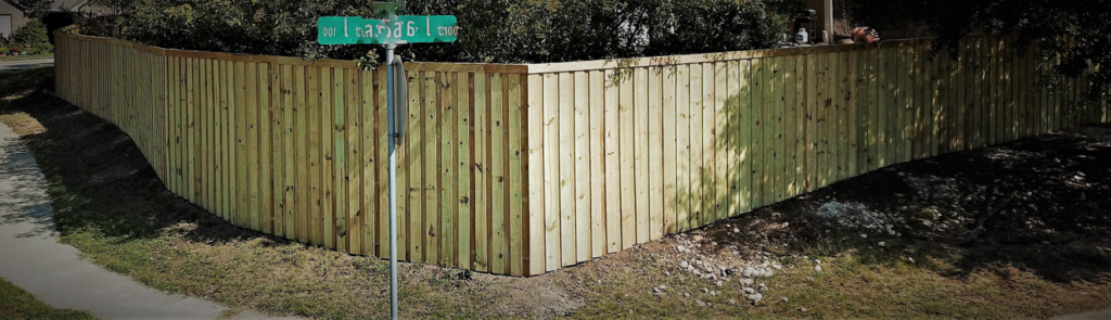 A long, curved wooden privacy fence installed on a corner residential lot by G Squared Fencing & Services LLC in New Braunfels, TX.