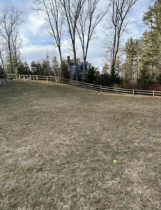 A curved wooden split-rail fence installed on an incline by Hunter & Sons Fence in Burlington, MA.