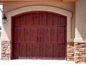 A custom arched wood-style garage door with decorative hardware installed by Mountain Fox Garage Doors in Colorado Springs, CO.