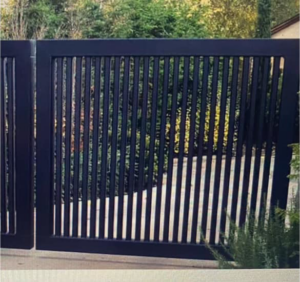 A custom-designed black metal driveway gate with vertical slats, installed by Gonzalez Iron Work in Oakland, CA.