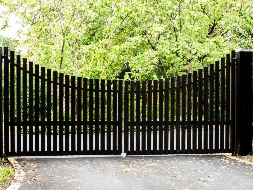 A custom black wood driveway gate, expertly installed by OneGuard Fencing in Vestavia Hills, AL.