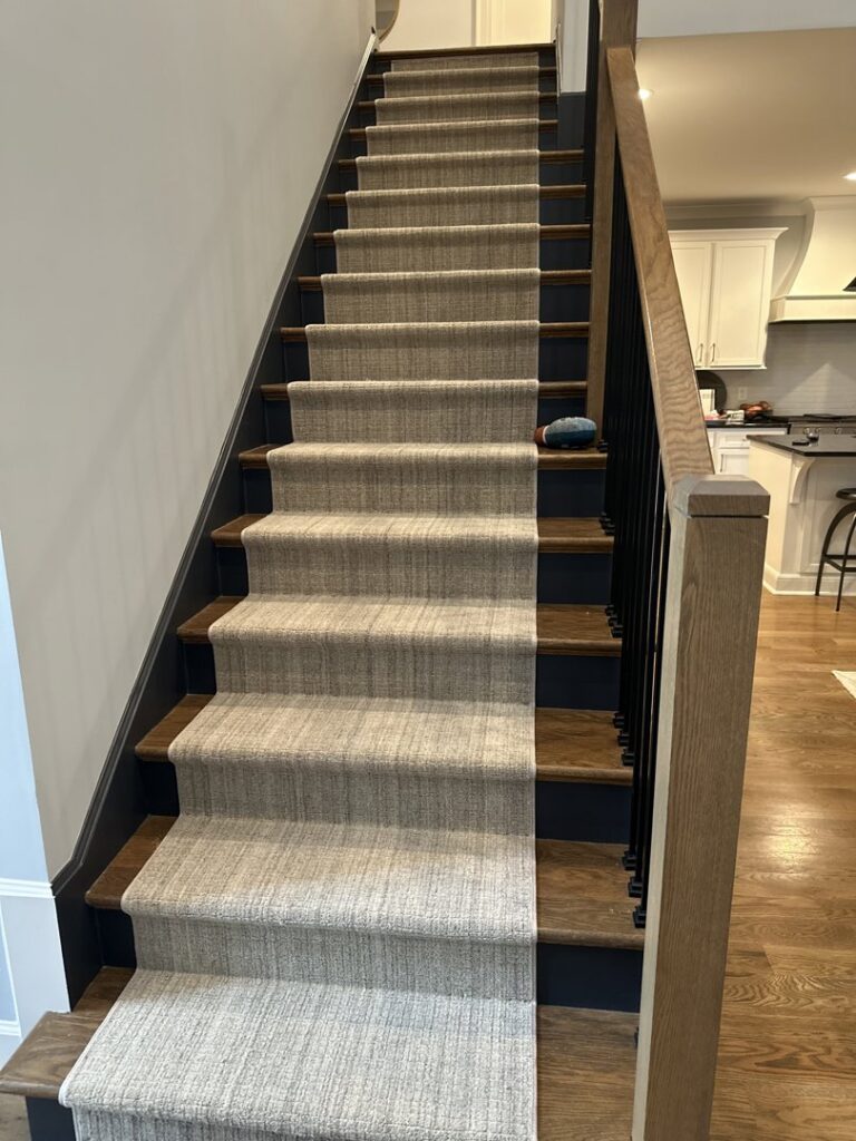 A custom carpet runner professionally installed on a staircase by Faith and Grace Flooring in Murfreesboro, TN.