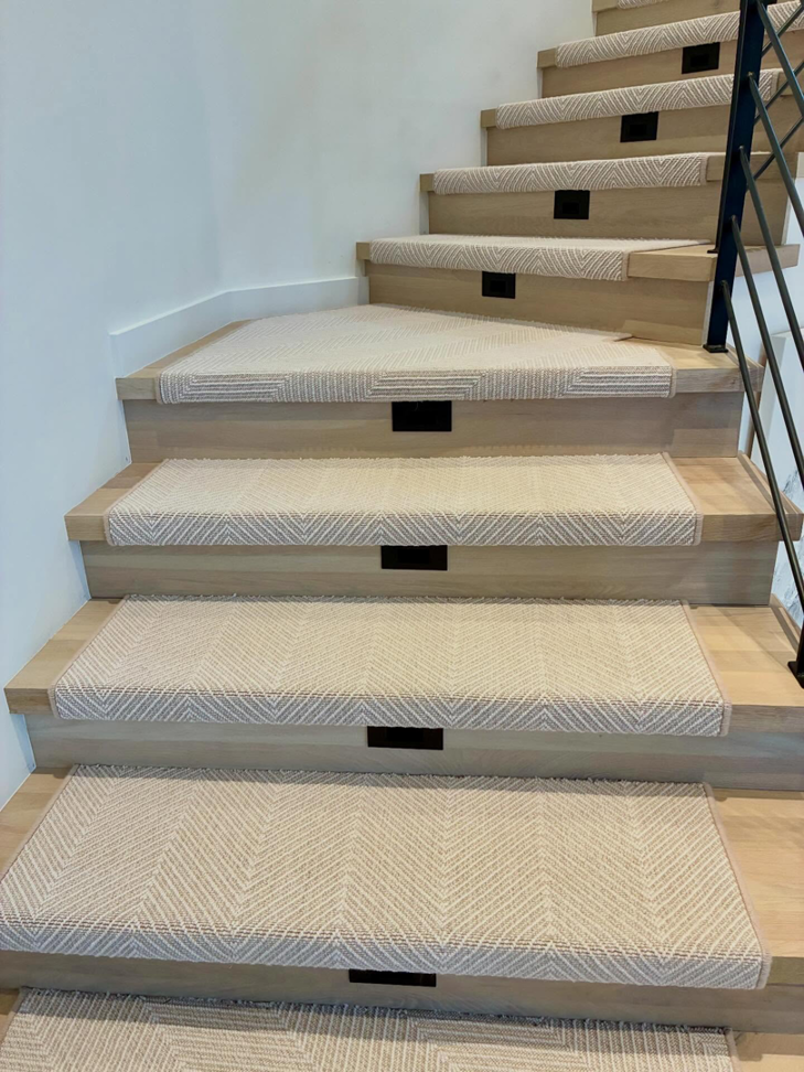 Custom carpet stair runners expertly installed on a curved staircase by Trademark Flooring in West Jordan, UT.