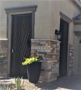 Two custom dark metal gates with a diagonal slat pattern, installed by Custom Customs Inc. in Henderson, NV.