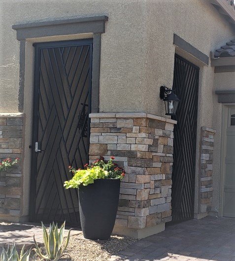 Two custom dark metal gates with a diagonal slat pattern, installed by Custom Customs Inc. in Henderson, NV.