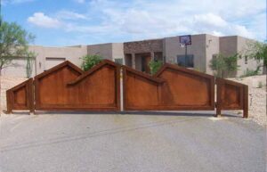 A custom decorative metal entry gate installed in front of a home by Fence Company Tucson in Tucson, AZ.