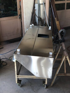 A custom fabricated sheet metal duct or component on a stand, ready for installation by Carlsbad Heating & Cooling in Carlsbad, NM.