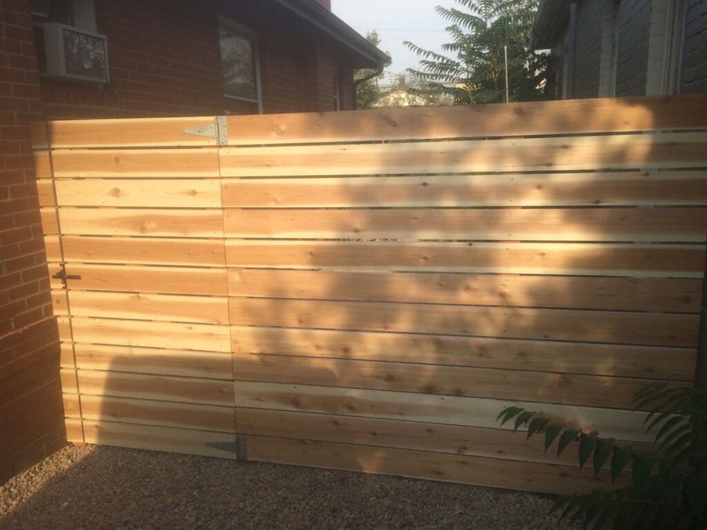 A custom horizontal slat fence with an integrated gate, installed by Accent Fence & Design in Lakewood, CO.