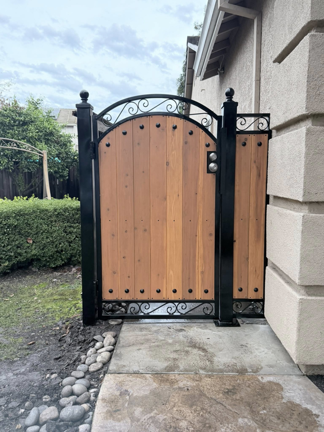 A newly installed custom iron and wood pedestrian gate by Exclusive Custom Iron Works in Stockton, CA.