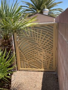 A custom metal backyard gate with an intricate palm leaf design, installed by Custom Customs Inc. in Henderson, NV.