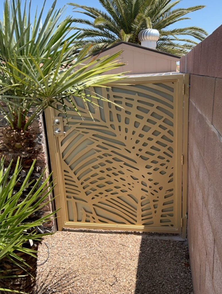 A custom metal backyard gate with an intricate palm leaf design, installed by Custom Customs Inc. in Henderson, NV.