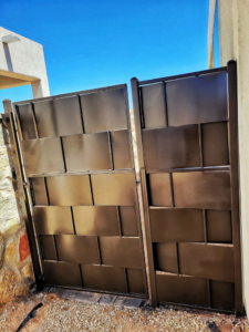 A custom dark metal gate installed by Las Cruces Fencing in Las Cruces, NM, providing secure property access.