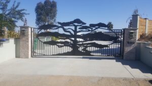 A custom metal gate featuring a large tree silhouette design, installed by Automated Entry Systems Inc in Escondido, CA.