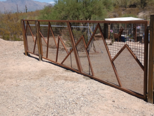 A custom metal mesh gate with a unique mountain design installed by Gotta Have It Fence in Tucson, AZ.