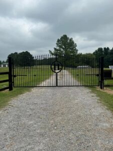 A custom ornate metal entry gate with an 'H' monogram installed by Smithfield Fence in Crowder, MS.