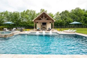 A custom swimming pool with a cabana and decorative water features by Top Tier Pools in Franklin, TN.