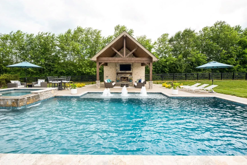 A custom swimming pool with a cabana and decorative water features by Top Tier Pools in Franklin, TN.