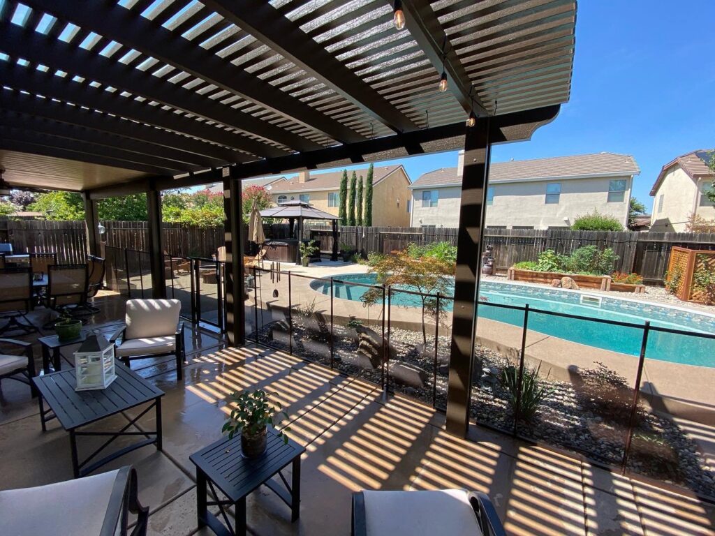 A custom black mesh pool safety fence with a gate, installed by Golden State Baby Barrier in Sacramento, CA.