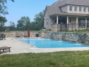 A custom pool featuring decorative stone waterfalls, a project by Luxury Outdoors, your pool contractor in Murfreesboro, TN.
