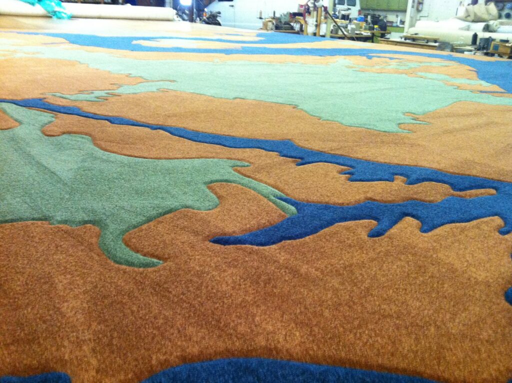 A large, custom-shaped multi-color carpet being fabricated by The Carpet Workroom in Needham Heights, MA.