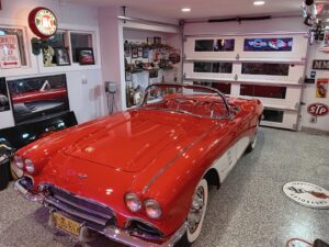 A custom white garage door with windows, installed by McDonald Overhead Door Inc. in Kenosha, WI, in a well-decorated garage.