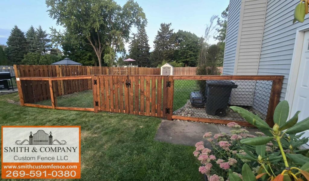A custom wooden fence with integrated chain-link sections and a gate, installed by Smith & Company Custom Fence LLC in Niles, MI.