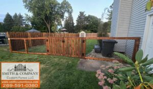 A custom wooden fence with integrated chain-link sections and a gate, installed by Smith & Company Custom Fence LLC in Niles, MI.