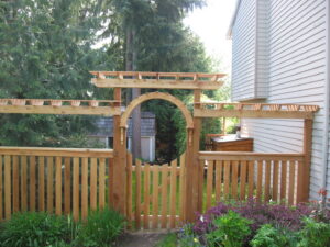 A custom wooden fence featuring an arched gate and decorative trellis top by Longhorn Fencing Eastern Idaho in Pocatello, ID.
