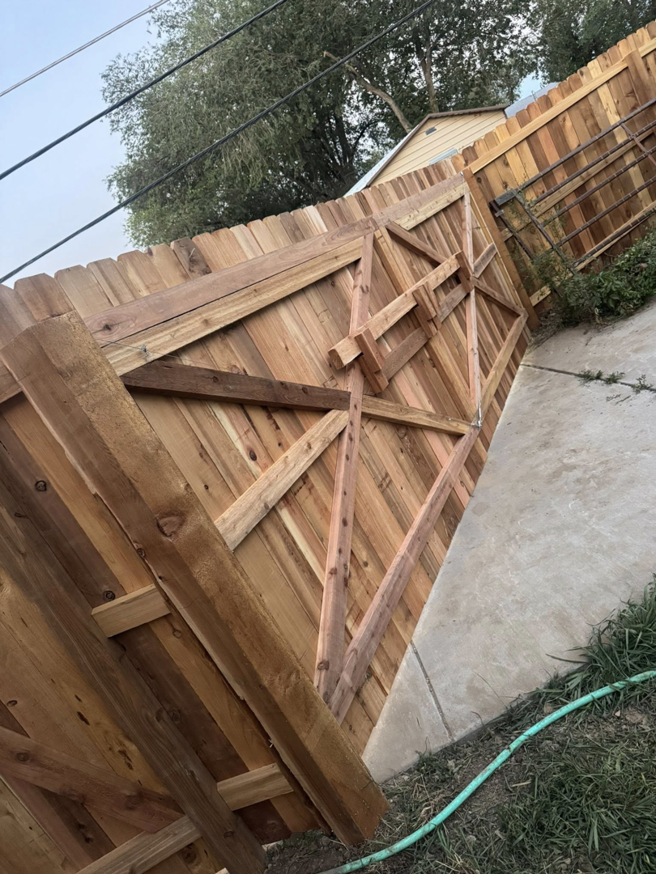 A custom-built wooden gate with diagonal bracing by HG Fencing LLC in Fountain, CO.