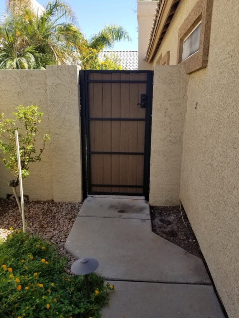 A custom wood gate integrated into a stucco wall, installed by SFA Contracting LLC in Tucson, AZ.