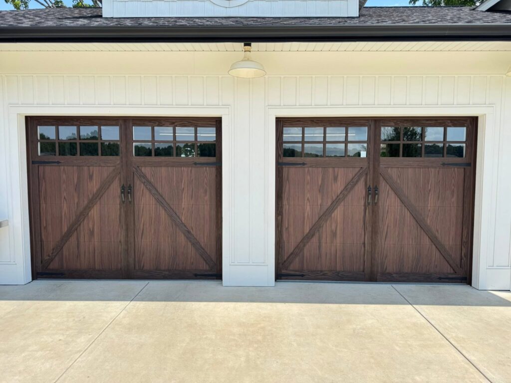 Custom wood-look garage doors with decorative hardware installed by Platinum Garage Door Services in Helena, AL
