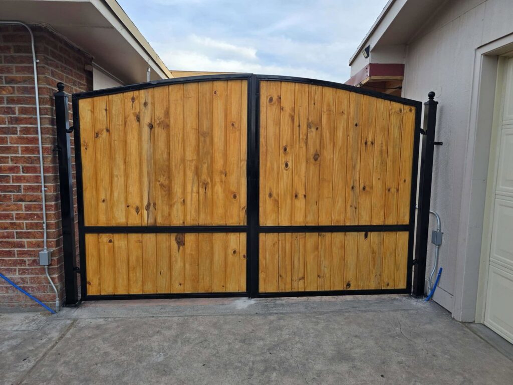 A custom wood and metal driveway gate installed by Iron Man Exteriors in Las Cruces, NM.