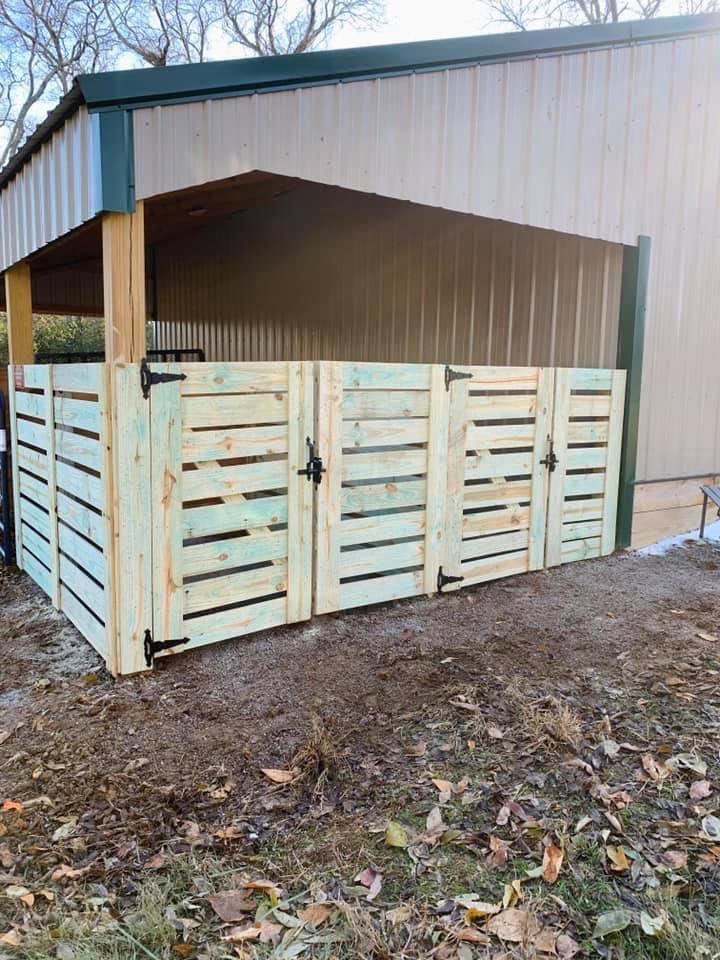 A custom wood slat enclosure with multiple gates, likely for utilities, installed by Alabama's Fencing in Huntsville, AL.
