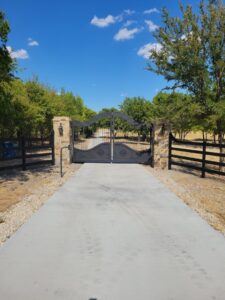 A close-up of a custom wooden gate with decorative metal handle and accents by Ft Worth Fence And Patio in Fort Worth, TX.