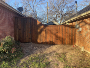 A custom-built wooden privacy fence with a gate section installed by Stevenson Brothers Fencing in Fort Worth, TX