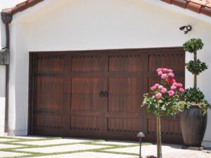 A custom wooden-style garage door with decorative hardware, enhancing a home's curb appeal by Morning Star Garage Doors in Phoenix, AZ.