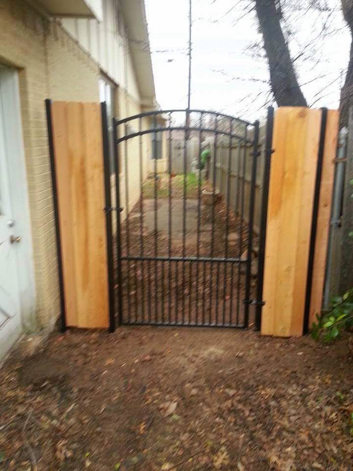 A custom wrought iron gate with decorative wood panels installed by Pro Insulation and Fence in Wichita Falls, TX.